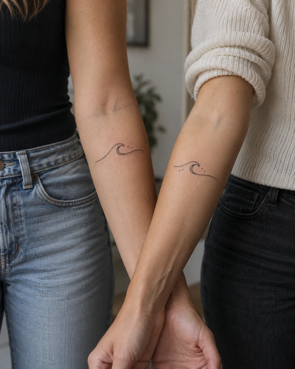 Complementary fine-line wave tattoos with crescent and dot accents on two inner forearms