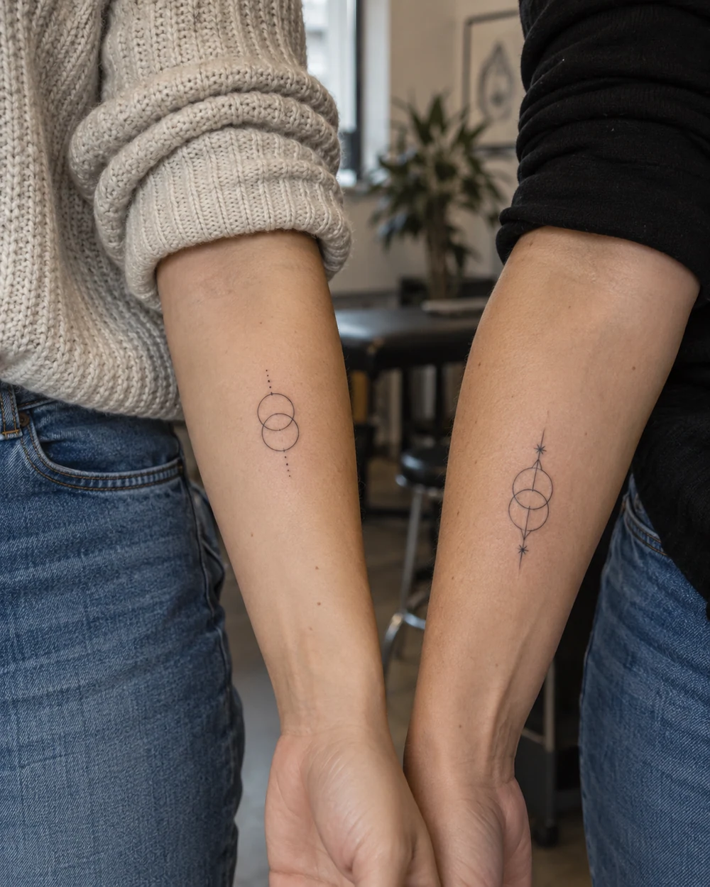 Two complementary fine-line interlocking circle tattoos on forearms