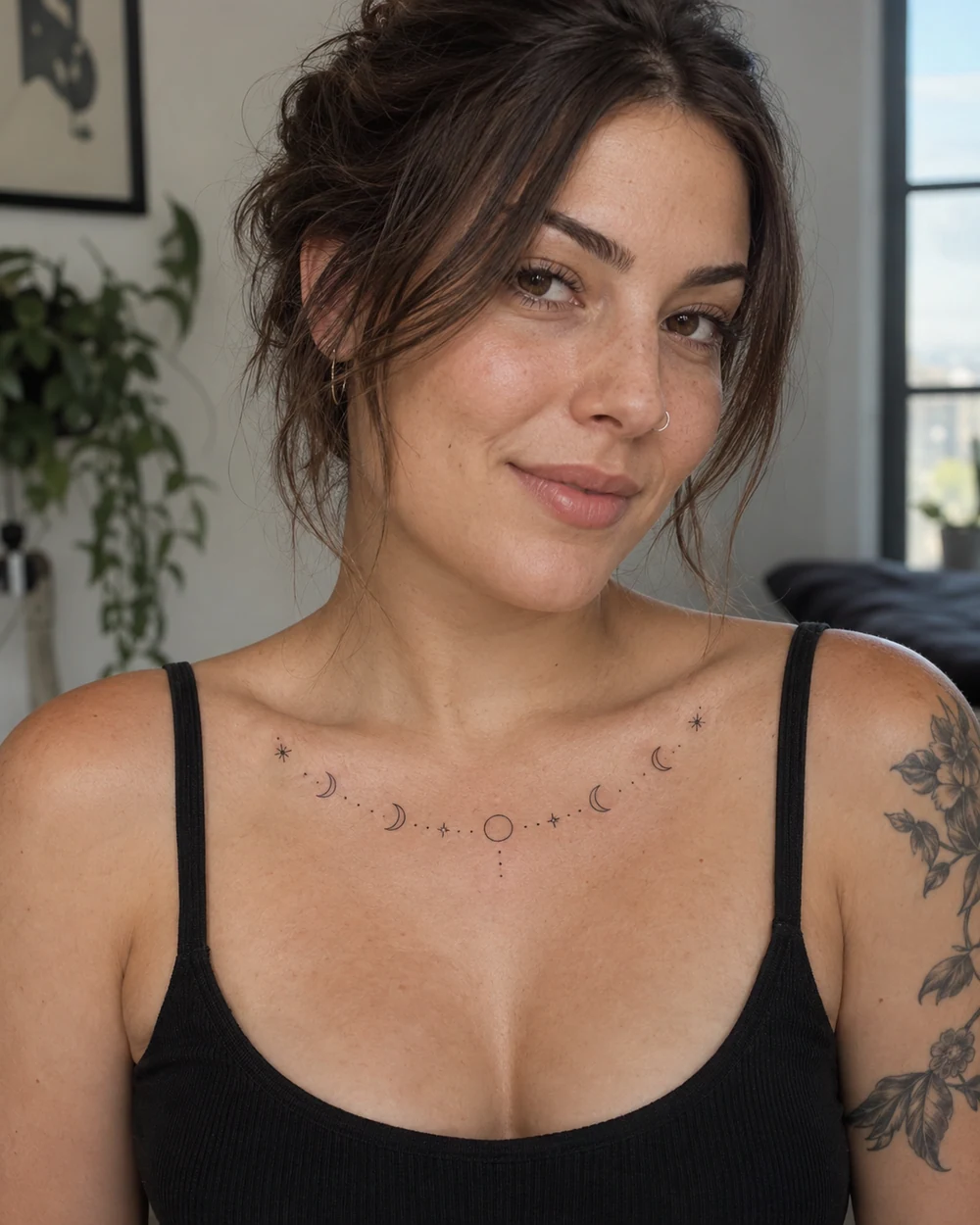 Fine-line lunar phase tattoo arranged in an arc across an adult woman’s upper chest