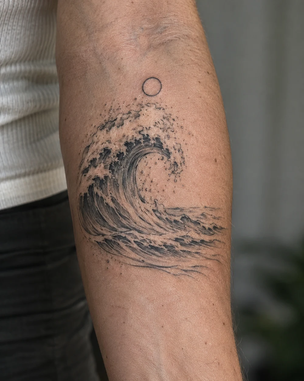 Black fine-line curling wave and open circle forearm tattoo